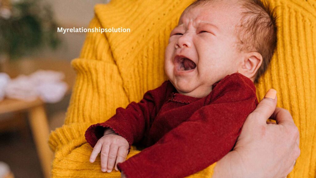 A baby crying in her mom's arm